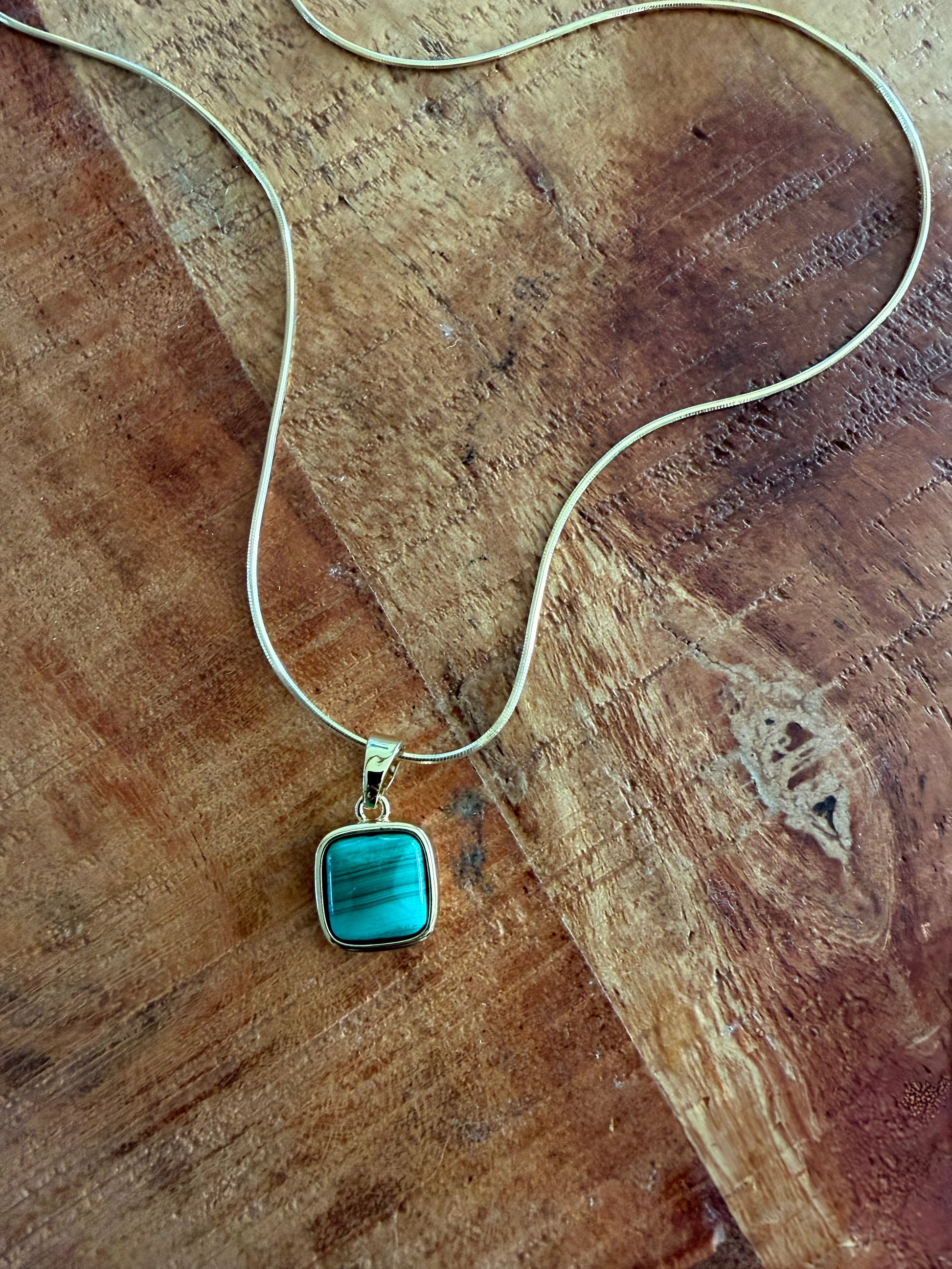 Necklace with a turquoise pendant on a wooden surface