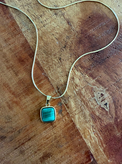 Necklace with a turquoise pendant on a wooden surface