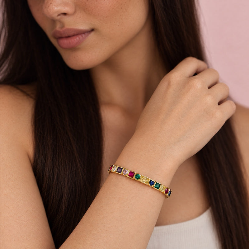 Close-up of the bangle worn at the wrist near the model's face, gemstones catching the light.