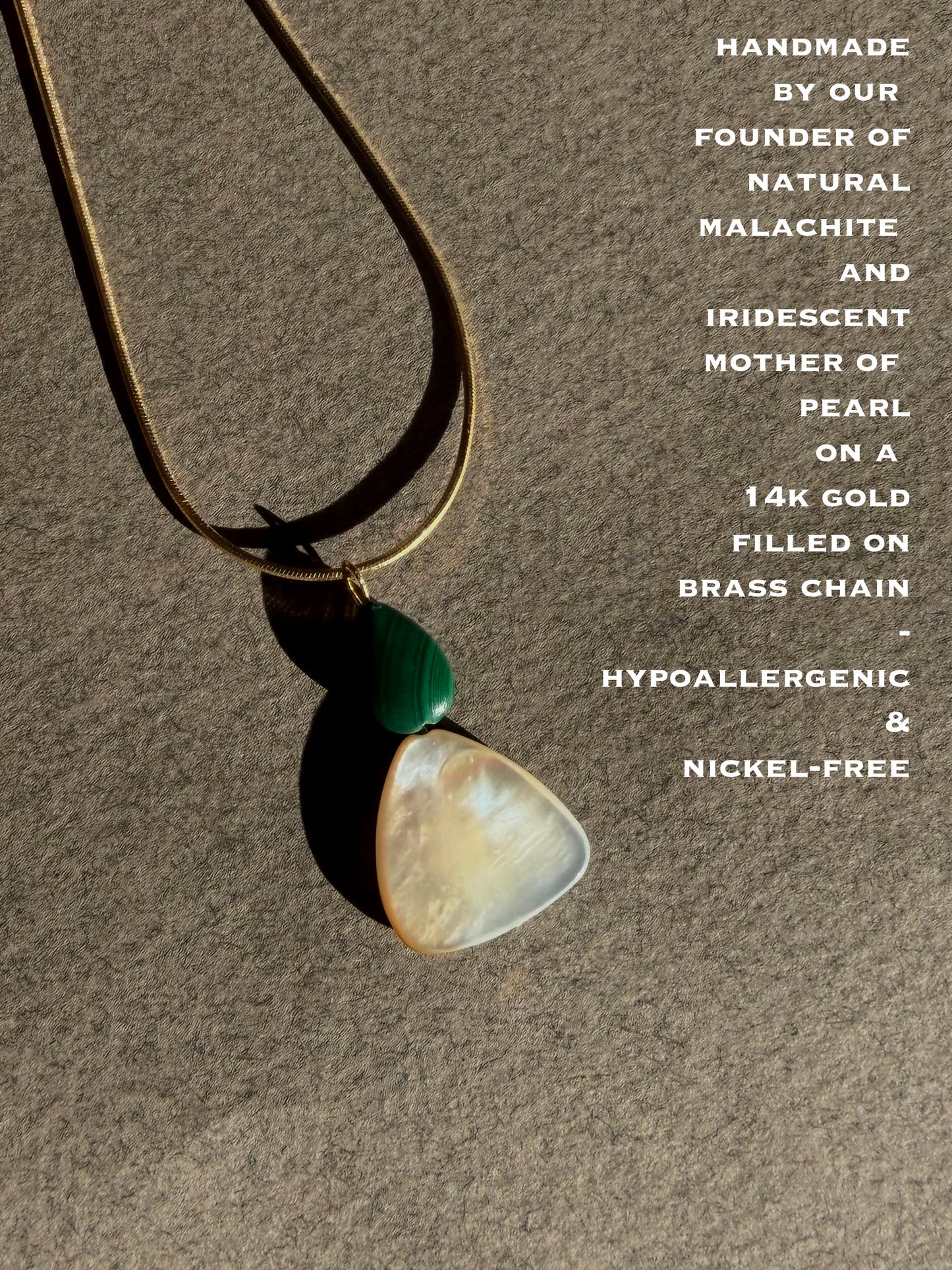 Necklace with natural malachite and iridescent mother of pearl pendant on a brown background