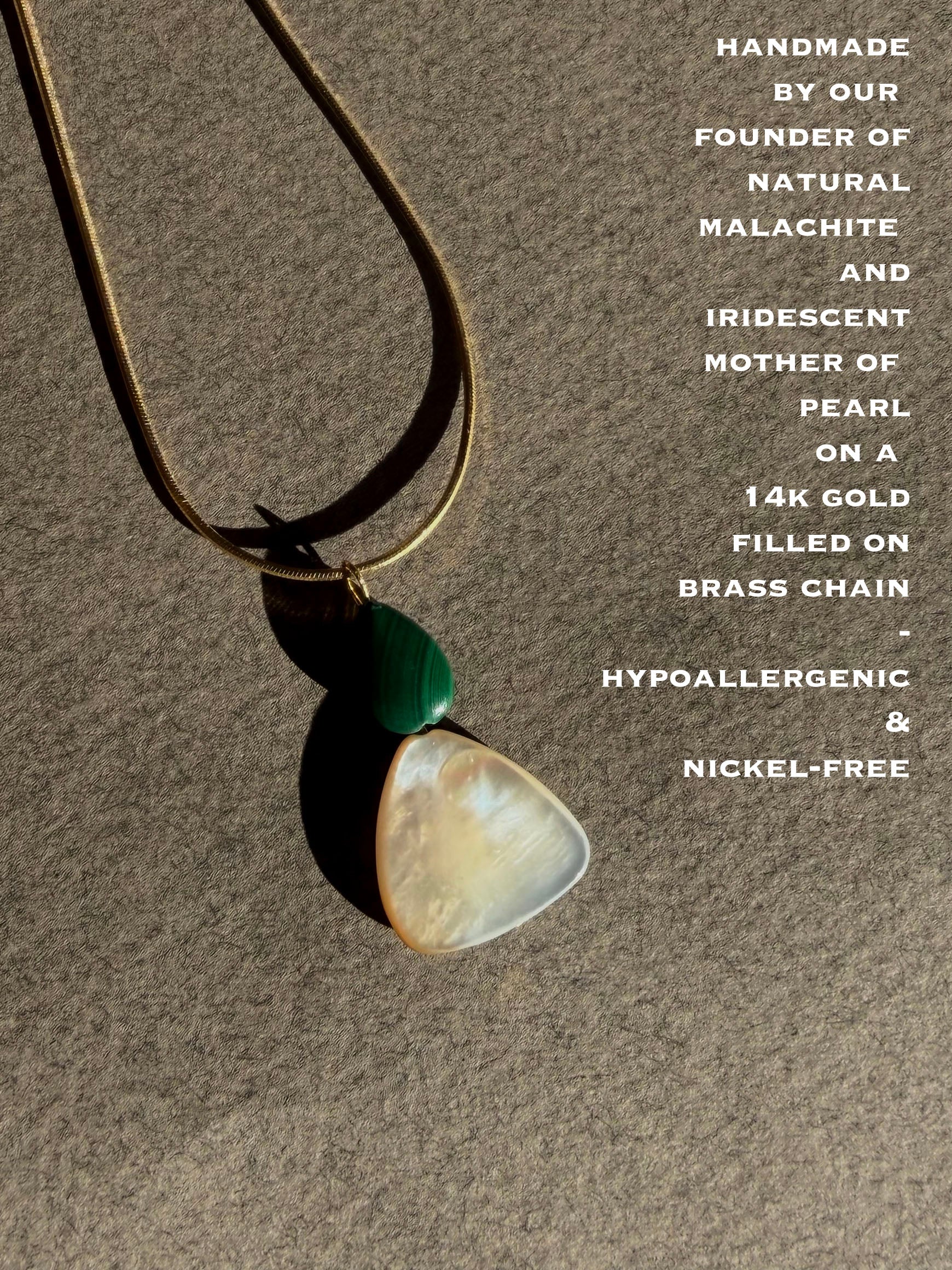 Necklace with natural malachite and iridescent mother of pearl pendant on a brown background
