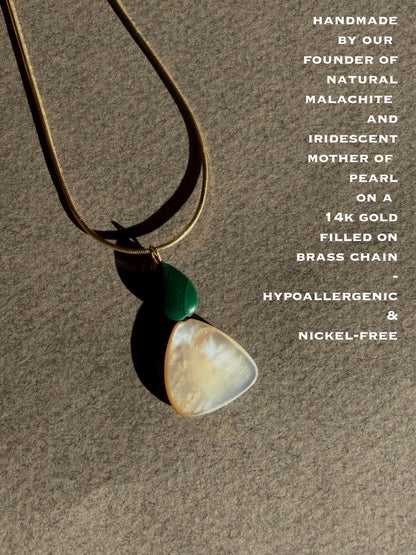 Necklace with natural malachite and iridescent mother of pearl pendant on a brown background