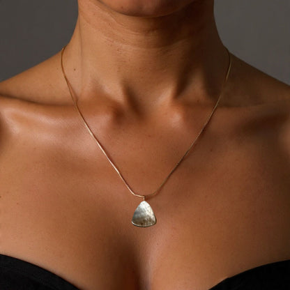 Gold filled Necklace with a mother of pearl pendant worn by a person against a neutral background