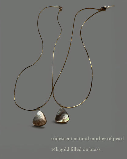 Pair of necklaces with iridescent natural mother of pearl drops on a gray background
