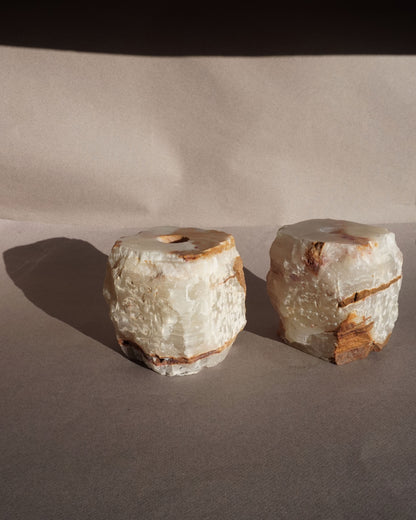 Organic modern onyx candle holders photographed with warm lighting highlighting natural stone texture
