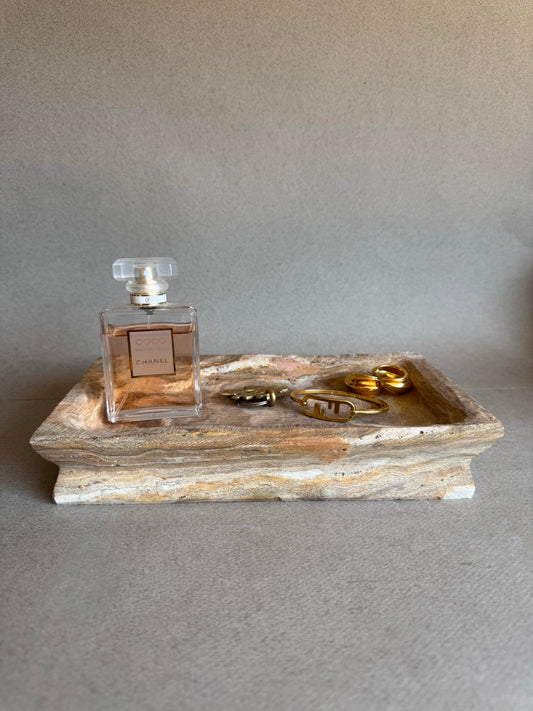 jewelry and perfume styled on stone tray