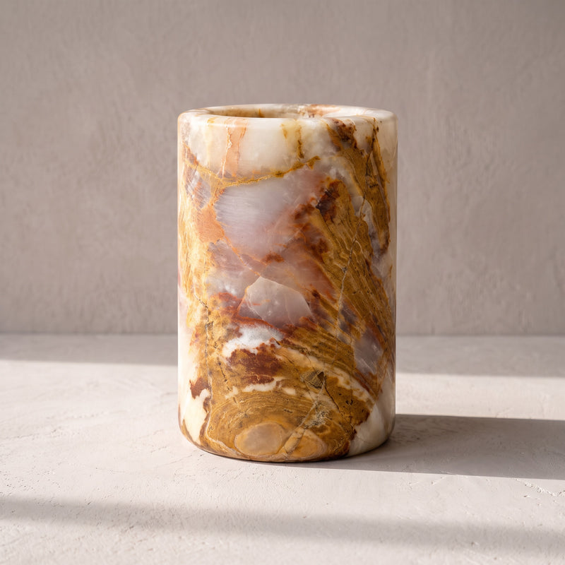 Ochre & Rust straight onyx vessel, straight on: cream onyx broken by brecciated ochre and rust veining, on a matte gray studio surface.