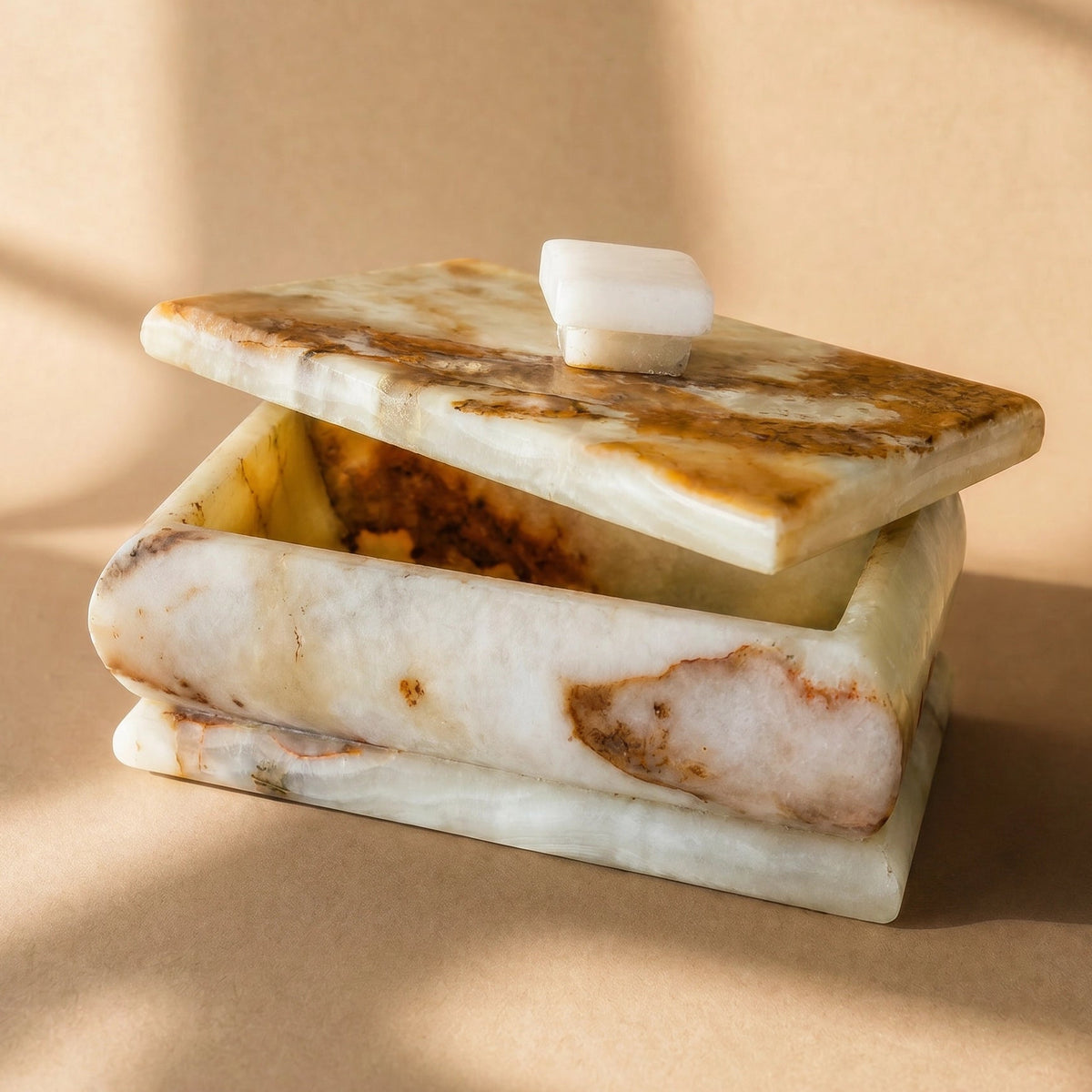 Onyx box with lid ajar, showing hollowed interior and rust-veined stone