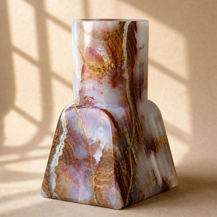Milky onyx vase showing banded rust and gold markings, square base rising to a round neck
