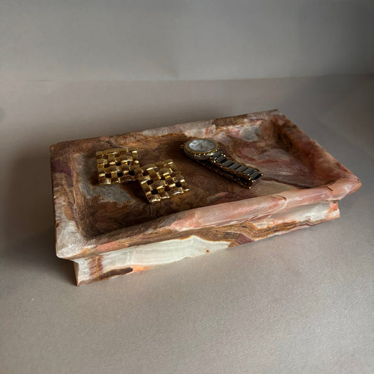 Decorative stone tray with decorative items on a gray surface