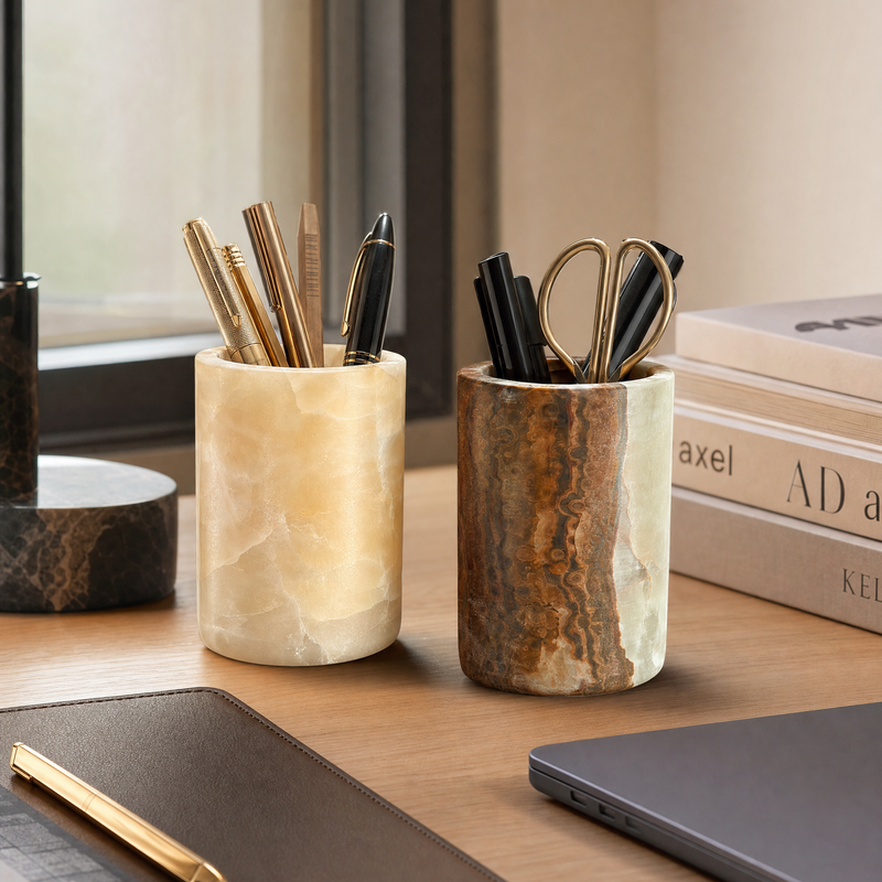 Two onyx pen holders with office supplies on a desk.