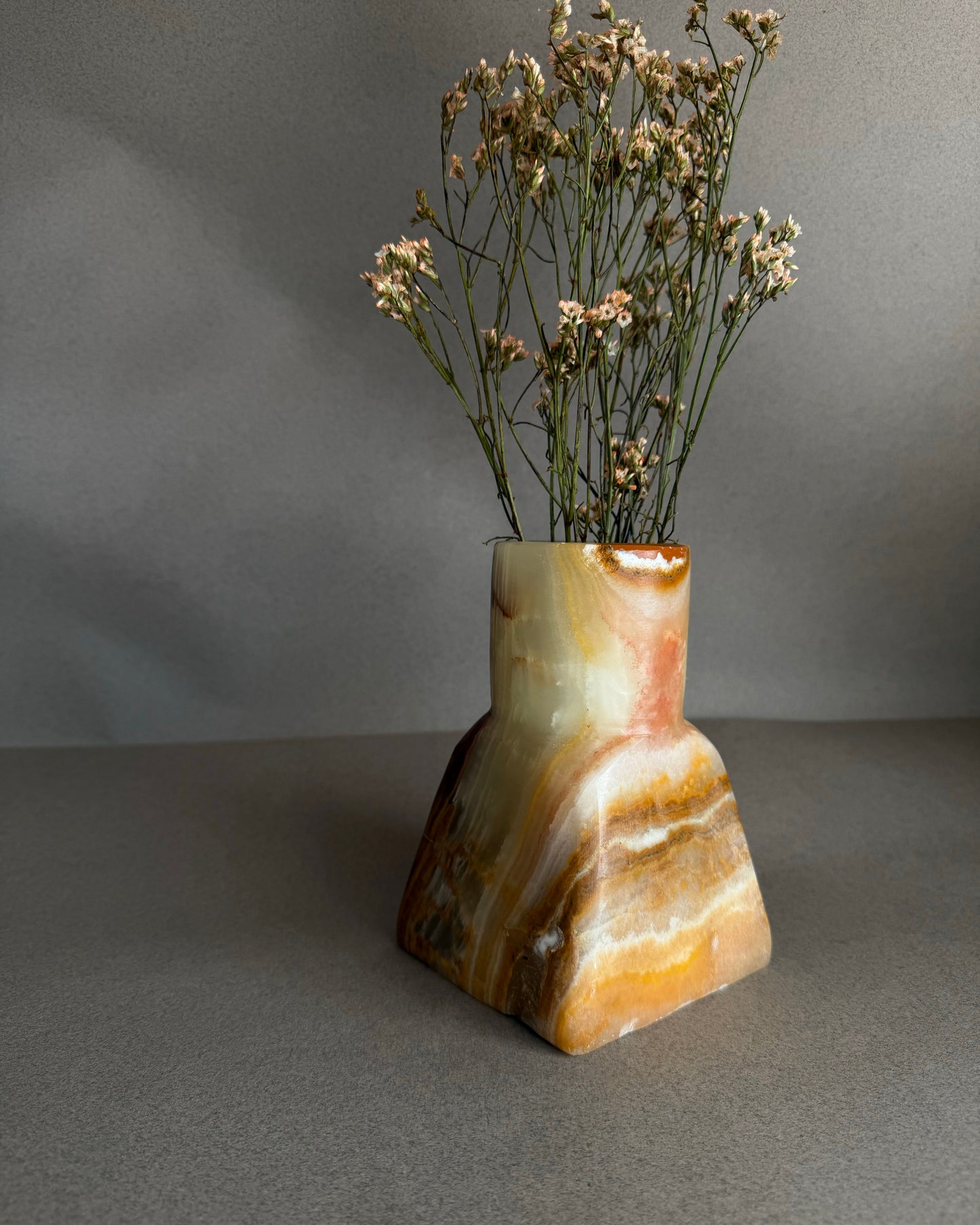 Stone onyx vase held in place on neutral backdrop showing scale and sculptural form
