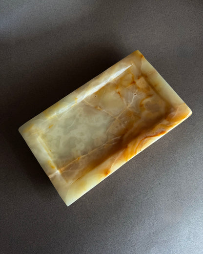 Minimalist onyx tray with peach and cream marbling photographed at angle, sculptural stone decor for entryway or dresser
