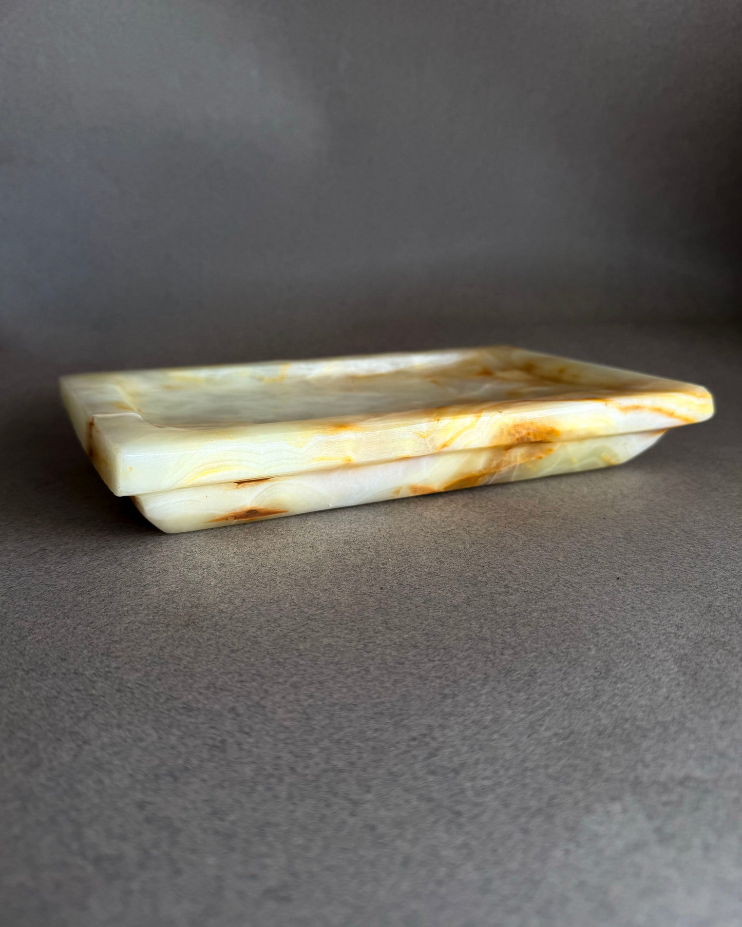 Rectangular stone honey onyx tray on a gray background