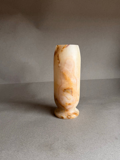 Decorative vase made of light-colored stone on a gray background