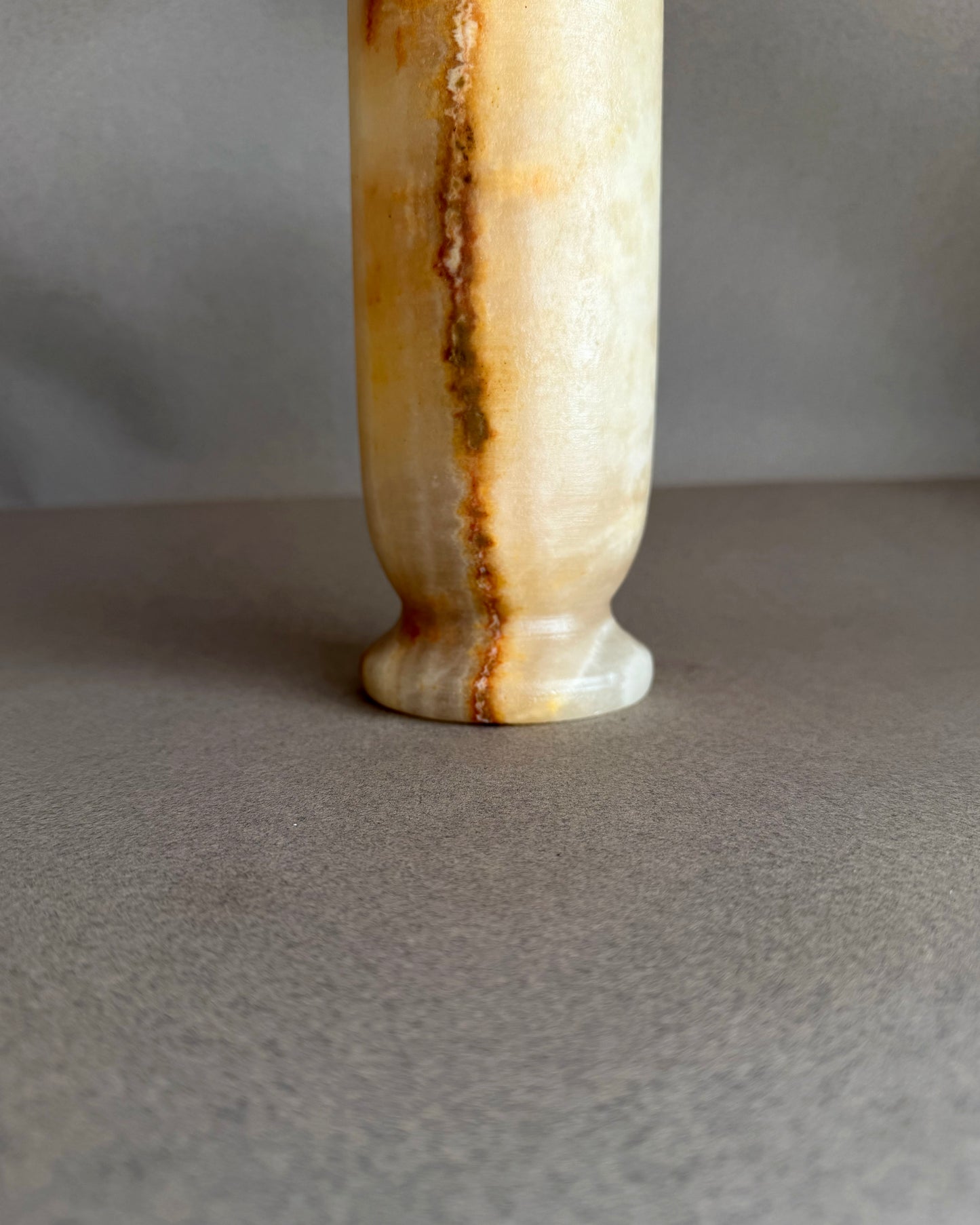 Decorative yellow peach vase with a ribbed texture on a gray background