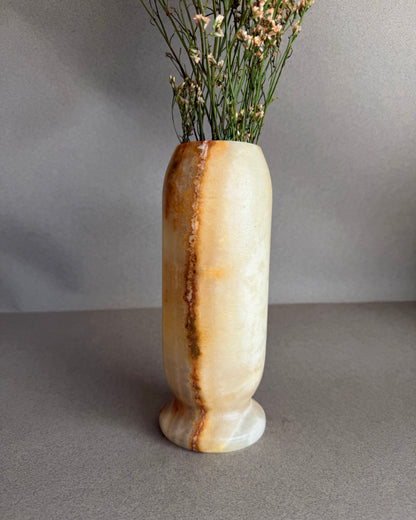 Decorative peach honey onyx marble stone vase with a natural stone pattern on a gray background