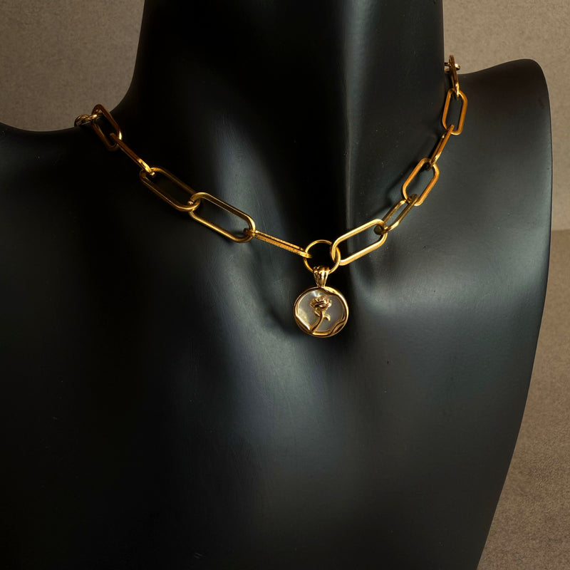 Modern gold chain necklace with mother of pearl pendant, soft iridescent pearl rose detail on neutral background
