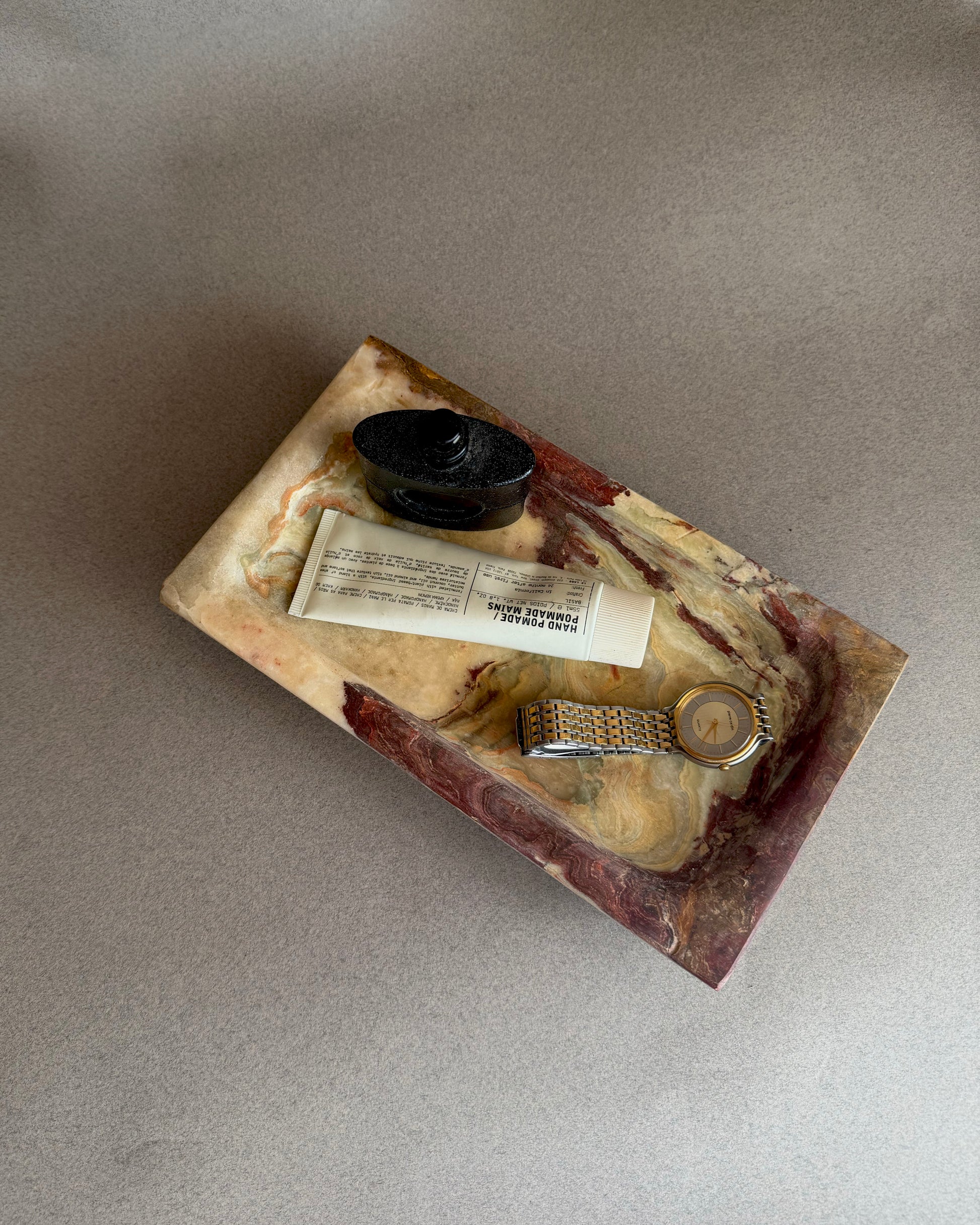 Organic modern onyx tray with raw stone texture and warm earth-toned veining on neutral background
