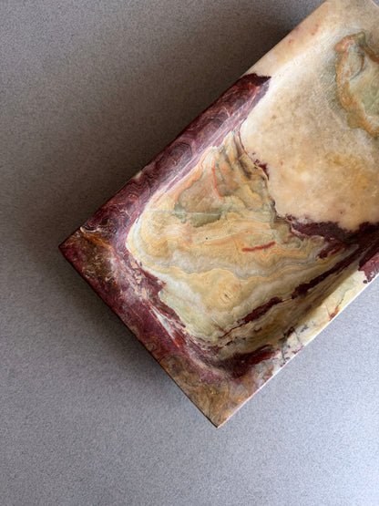 Organic modern onyx tray with raw stone texture and warm earth-toned veining on neutral background
