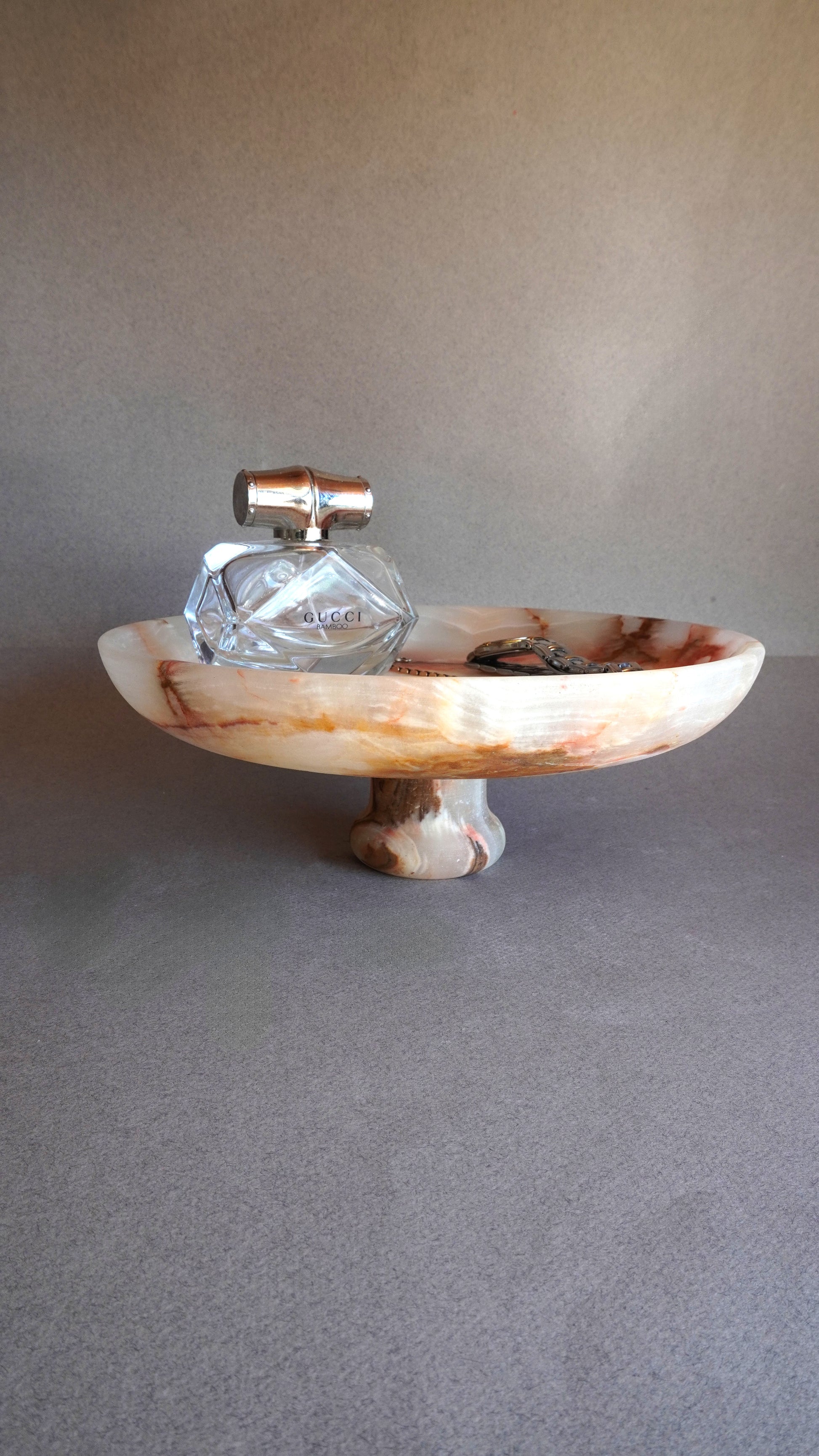 pink onyx  Decorative stone bowl with a crystal on a gray surface