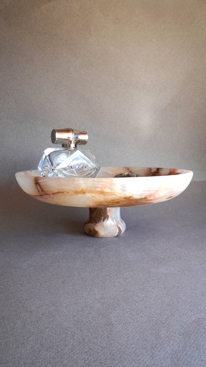 pink onyx Decorative bowl with a glass item on a gray surface