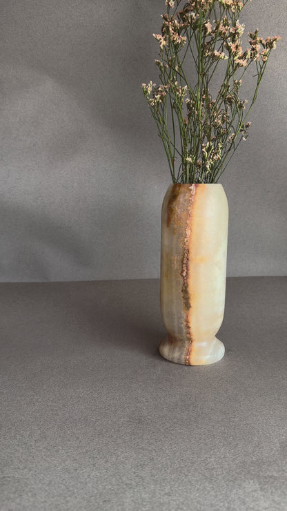 Hand-carved peach and amber onyx pedestal vase with ivory stone and natural brown veining, styled with dried florals

