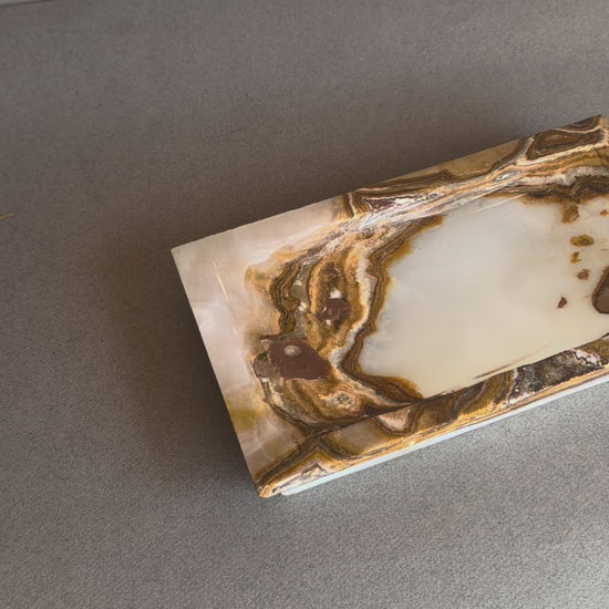 Rectangular raw onyx stone tray with sculpted edges and warm brown contrast
