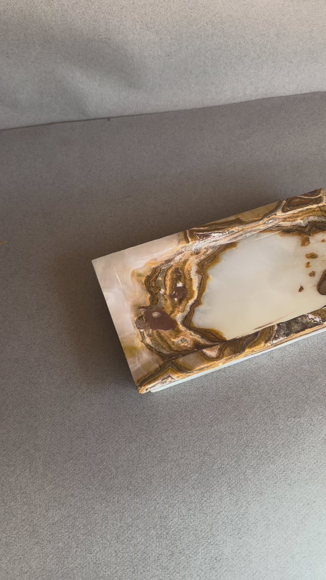 Rectangular raw onyx stone tray with sculpted edges and warm brown contrast
