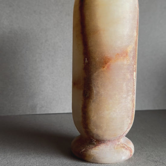 Onyx vase in soft honey and peach tones with marbled amber mineral bloom on front.

