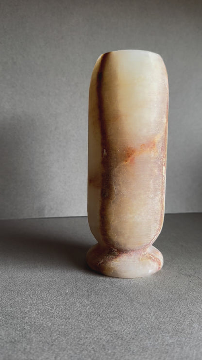 Onyx vase in soft honey and peach tones with marbled amber mineral bloom on front.

