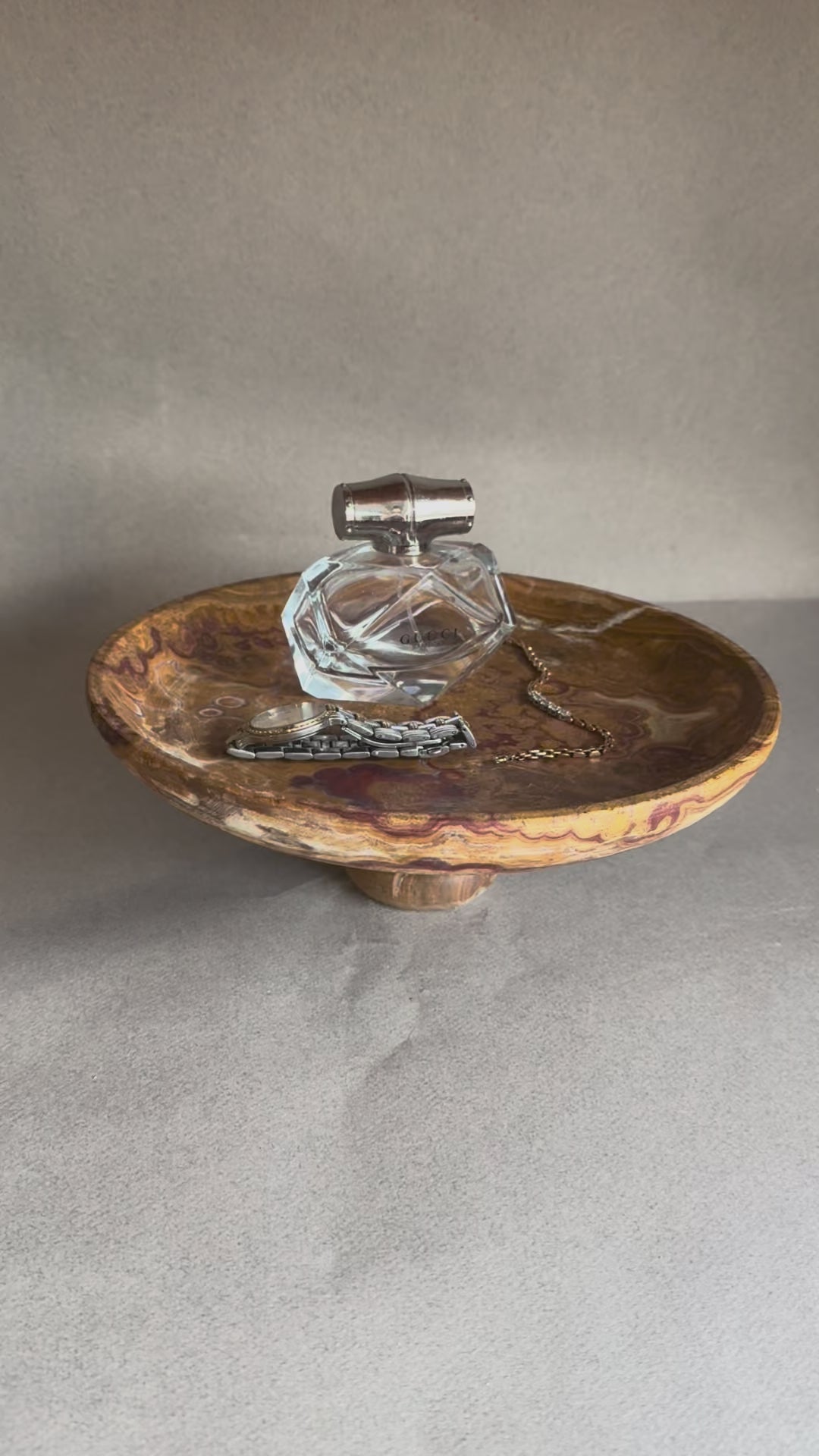 Footed onyx pedestal bowl showing earthy brown and amber veining, artisan stone centerpiece for rustic or modern decor.