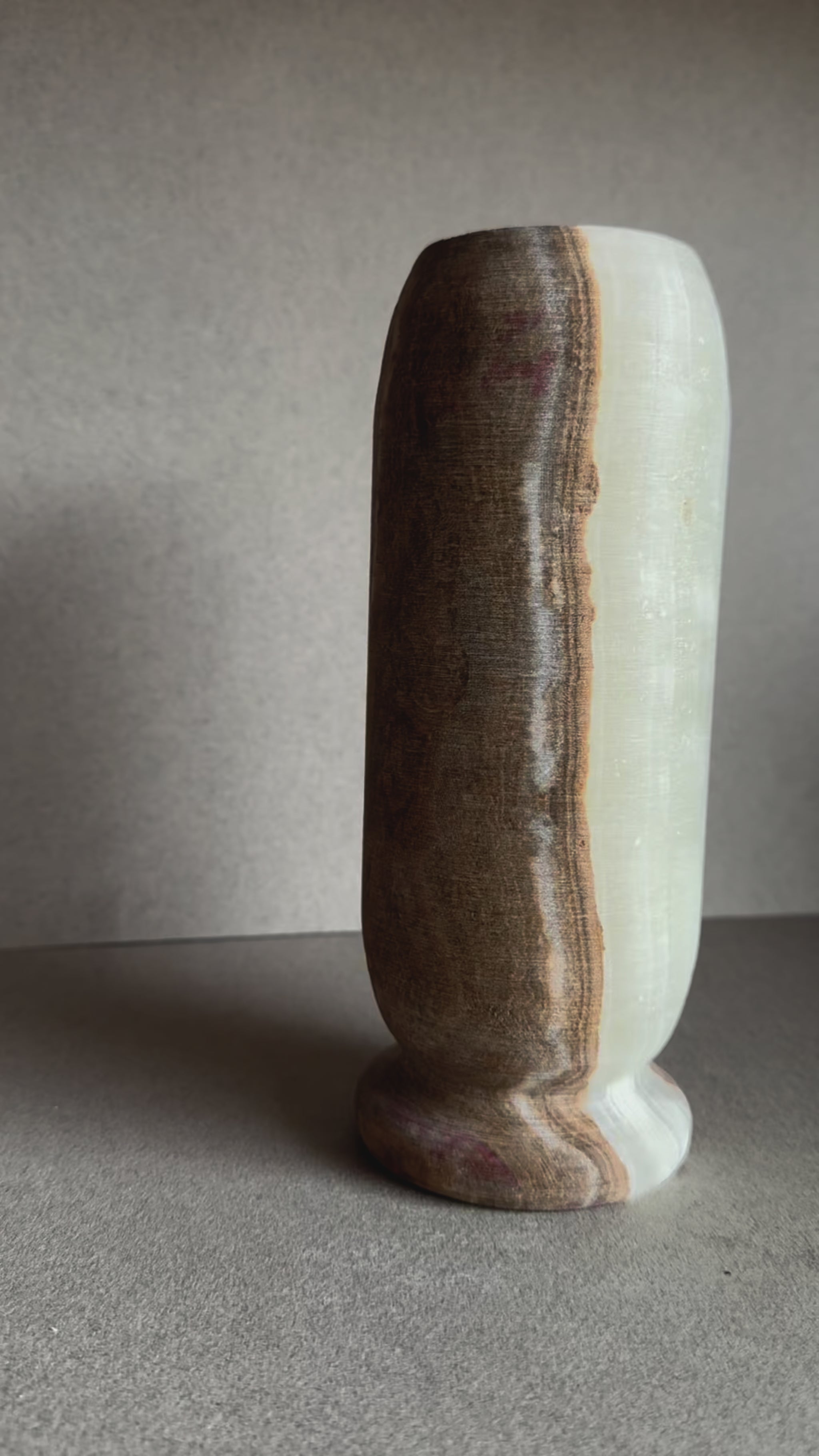Hand-carved onyx vase with walnut, blush, and ivory veining in a tall cylindrical form.

