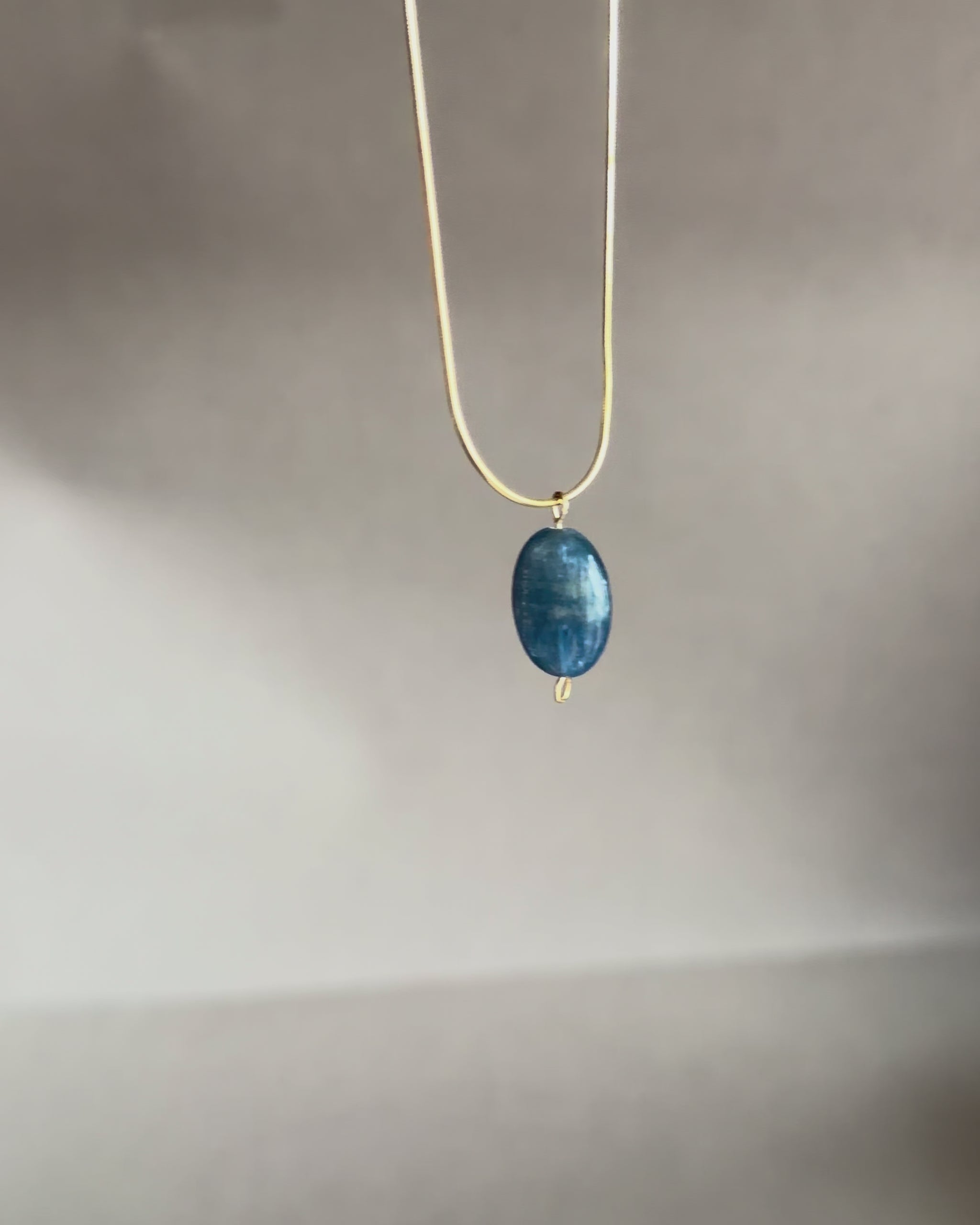 blue kyanite gemstone pendant on a gold snake chain necklace iridescent stone minimalist necklace jewelry