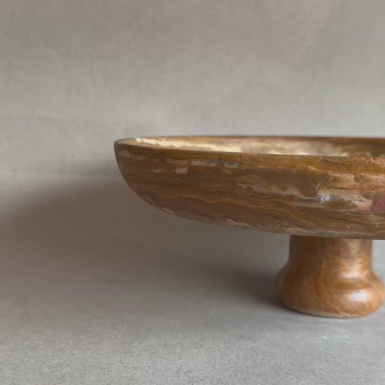 Natural stone fruit bowl with warm golden brown veining

