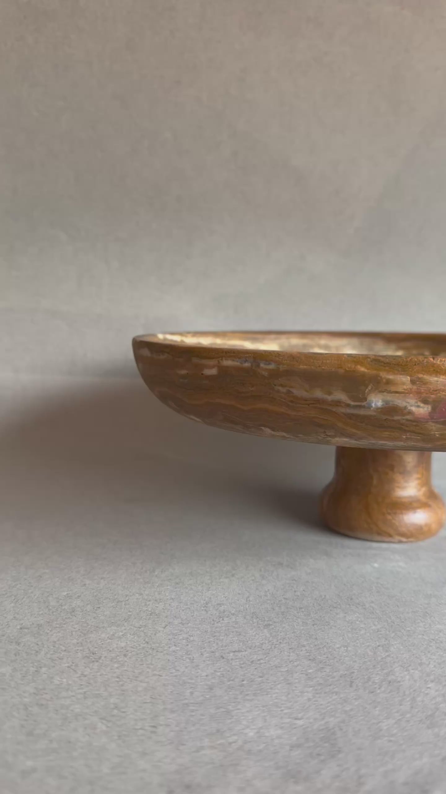 Natural stone fruit bowl with warm golden brown veining

