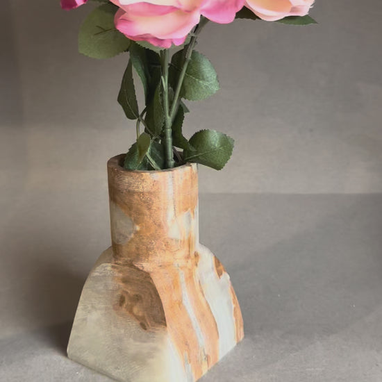 Hand-carved amber onyx vase with geometric square base and cylindrical top, styled with eucalyptus stems.