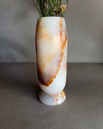 Marble-patterned vase with dried plants on a gray background