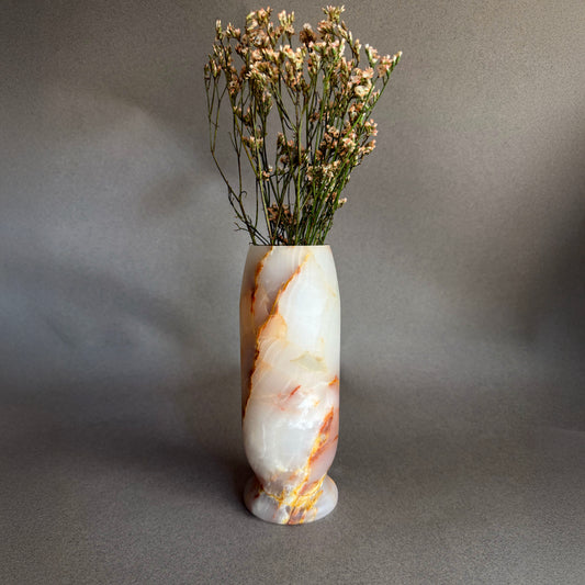 Marble-patterned onyx white honey vase with dried flowers on a gray background