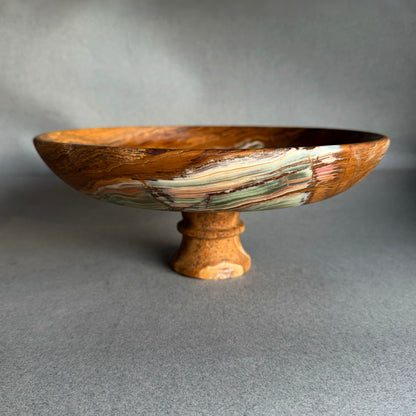 Hand-carved onyx pedestal bowl with deep rust brown exterior and wide shallow form, sculptural stone bowl on pedestal base
