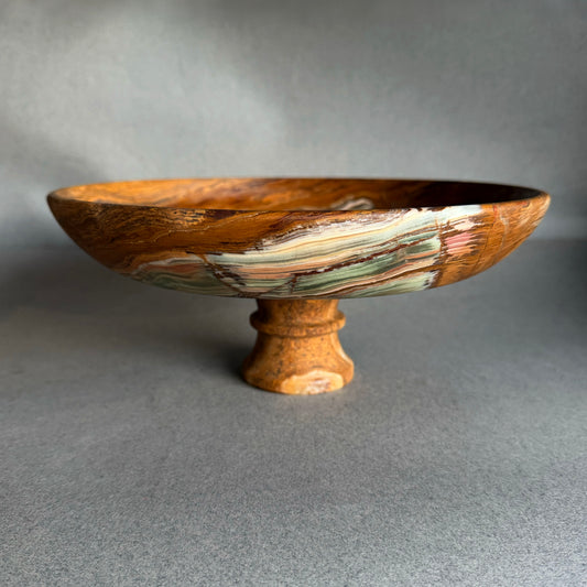 Hand-carved onyx pedestal bowl with deep rust brown exterior and wide shallow form, sculptural stone bowl on pedestal base
