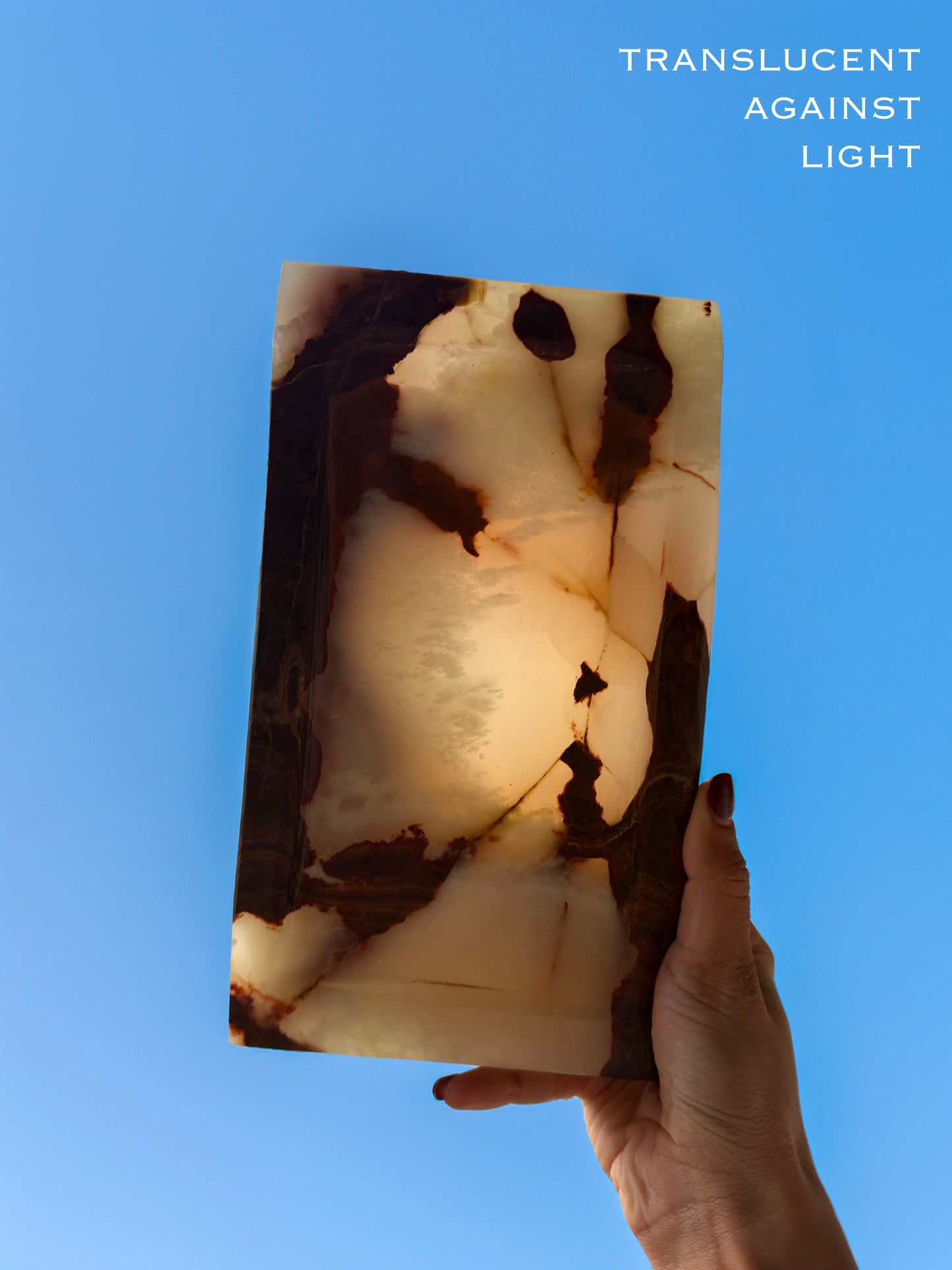 Hand holding a translucent stone against a blue background with text 'Translucent Against Light'.