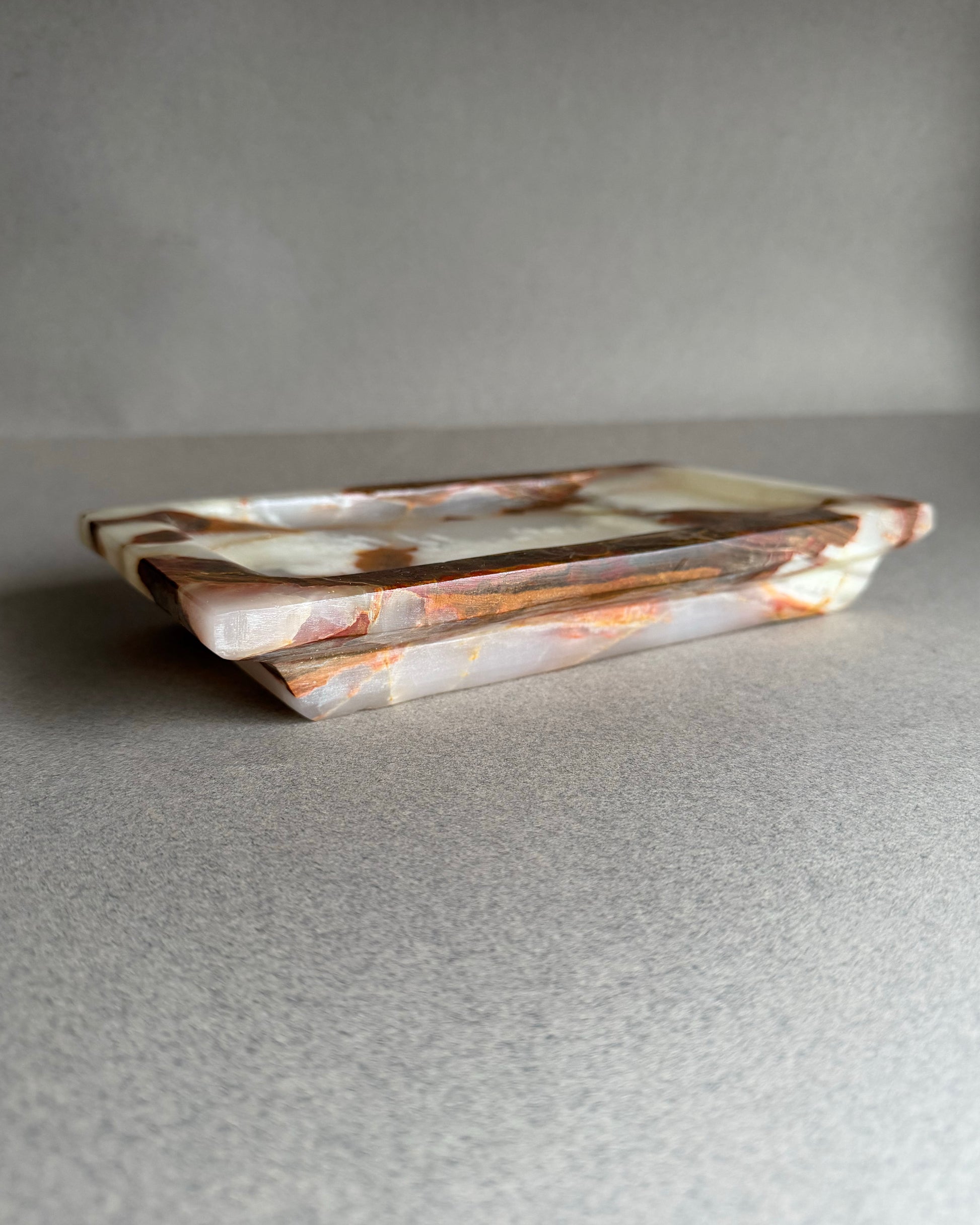 Rectangular ceramic tray with marbled pattern on a gray surface