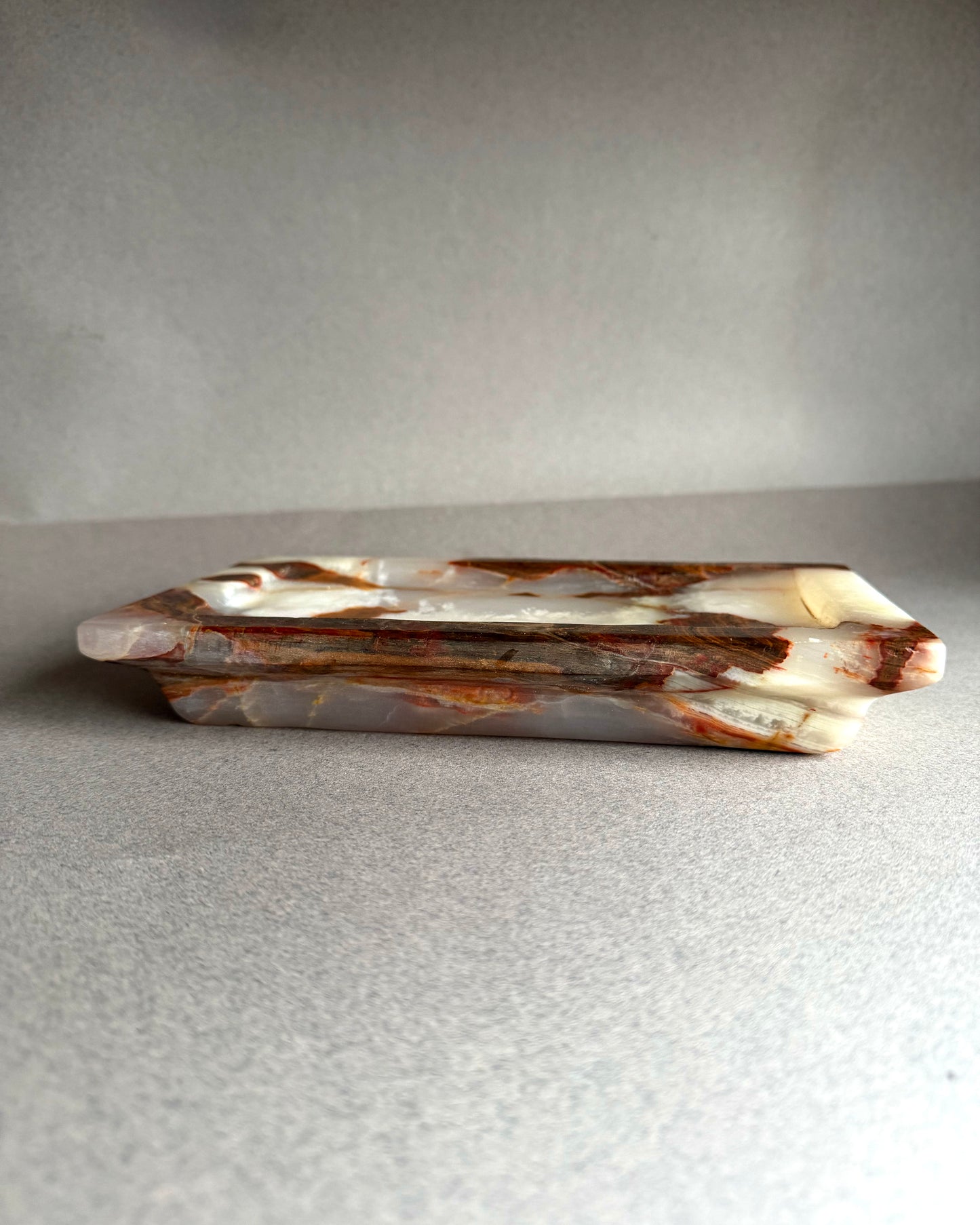 Decorative stone tray with brown and white marbled pattern on a gray background