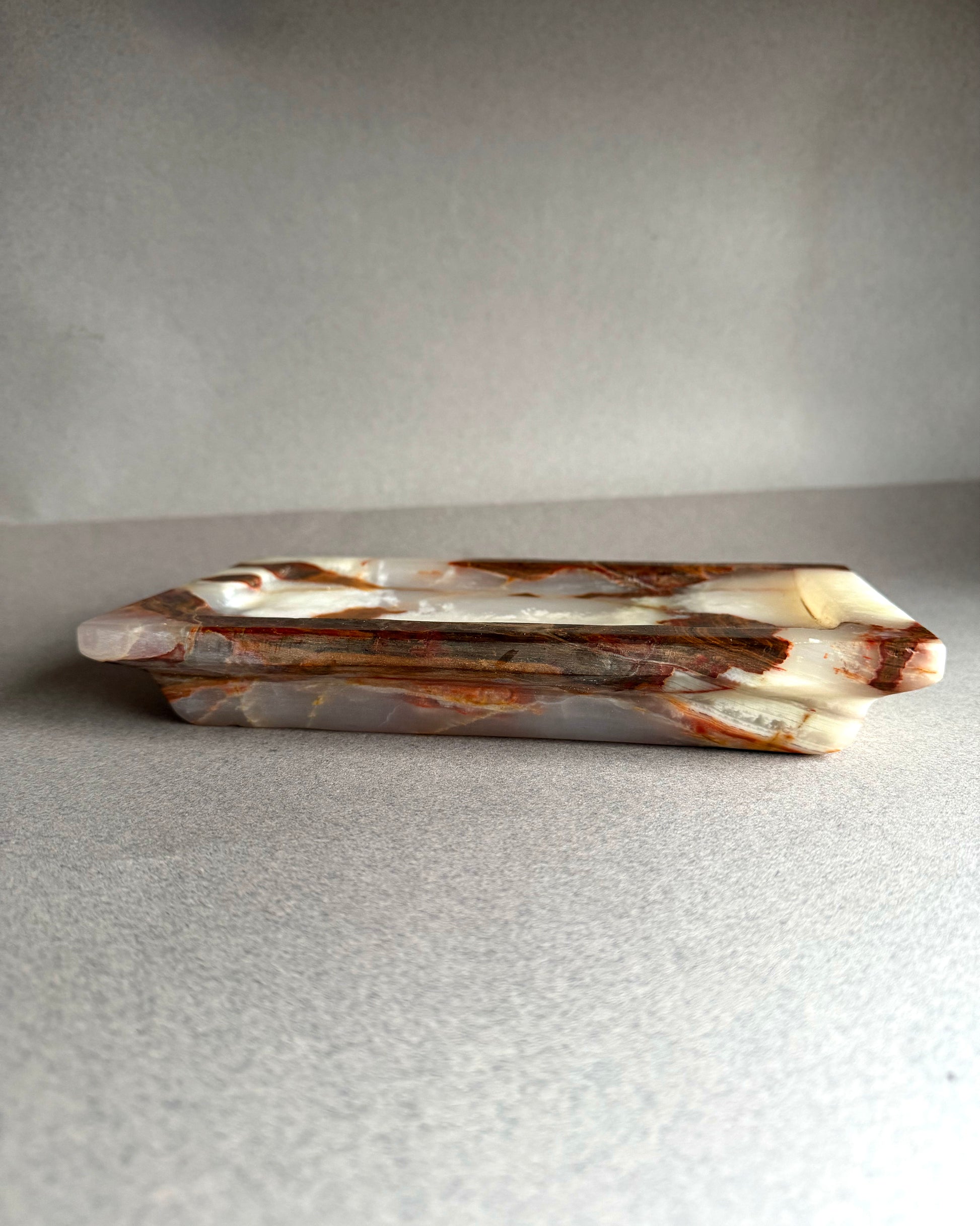 Decorative stone tray with brown and white marbled pattern on a gray background