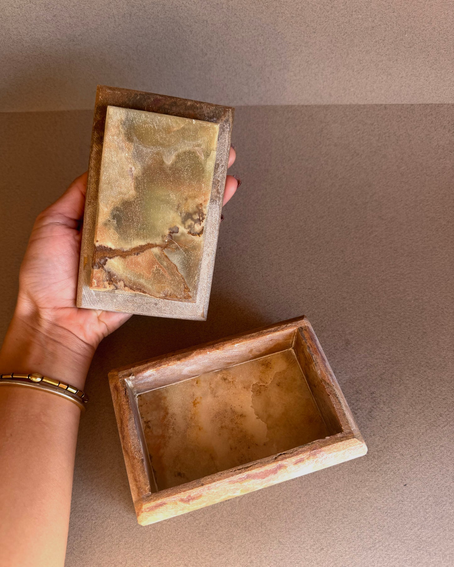 Raw onyx jewelry box with lid featuring earthy brown, amber, and blush veining