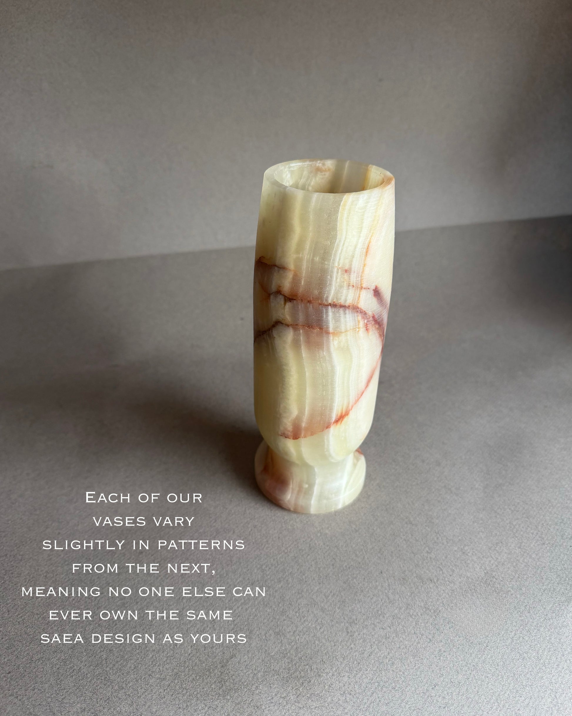 Marble-patterned vase on a gray surface with text about unique patterns.