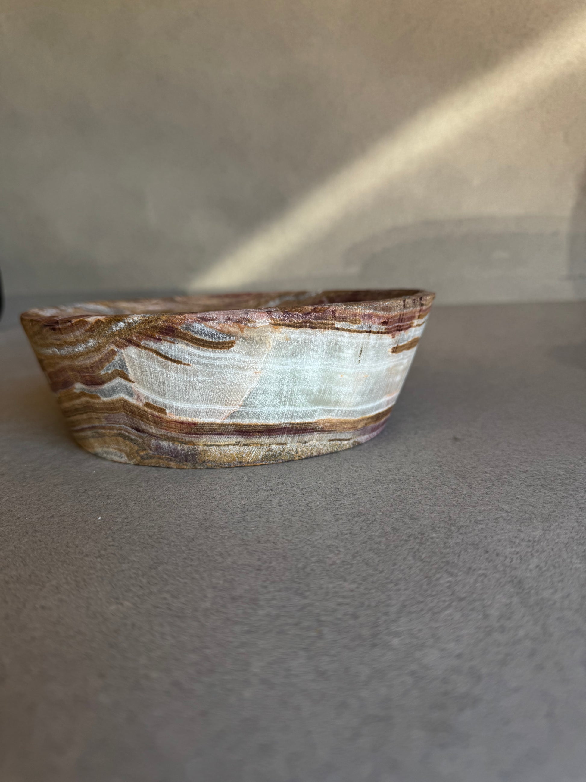 Neutral onyx catchall bowl with terracotta and ivory veining, sculptural stone decor