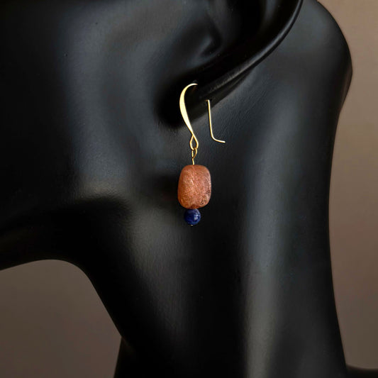 Earring with a orange bead and blue stone on a black mannequin. Handmade sunstone and sodalite drop earrings on gold filled hooks, minimalist gemstone jewelry
