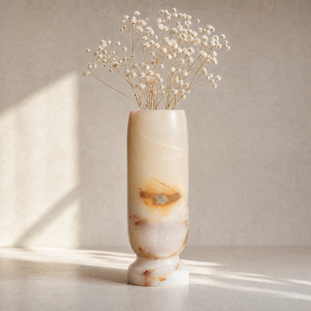 Decorative vase with dried flowers on a neutral background